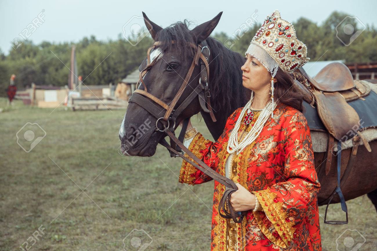 赤のドレスとジュエリーの中世の貴婦人は 馬に乗るをつもりです の写真素材 画像素材 Image