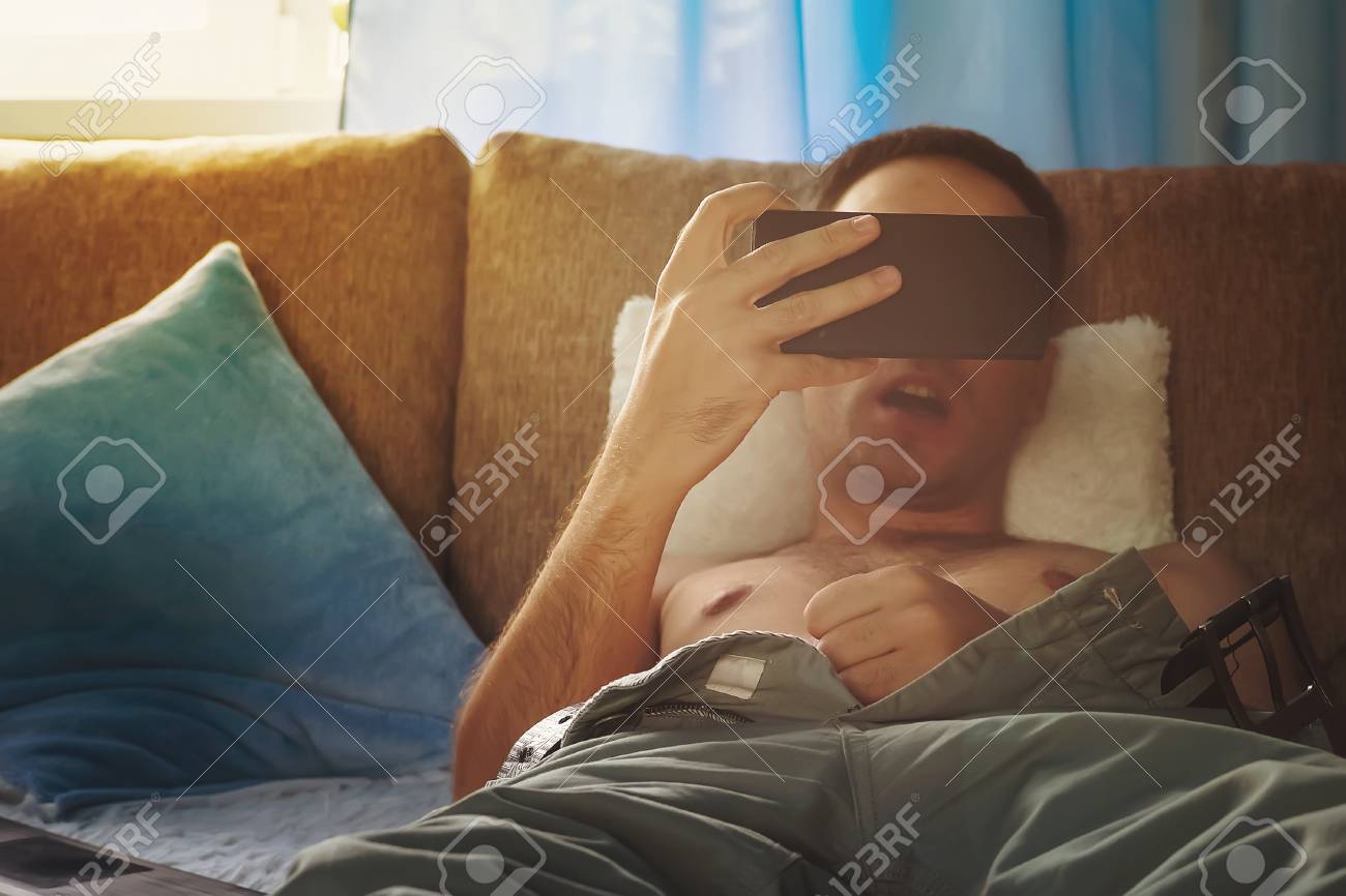 Young Naked Man Watching Pornography. Young Man Jerks Off On The Couch  Watching The Screen Of A Smartphone Stock Photo, Picture and Royalty Free  Image. Image 107019019.