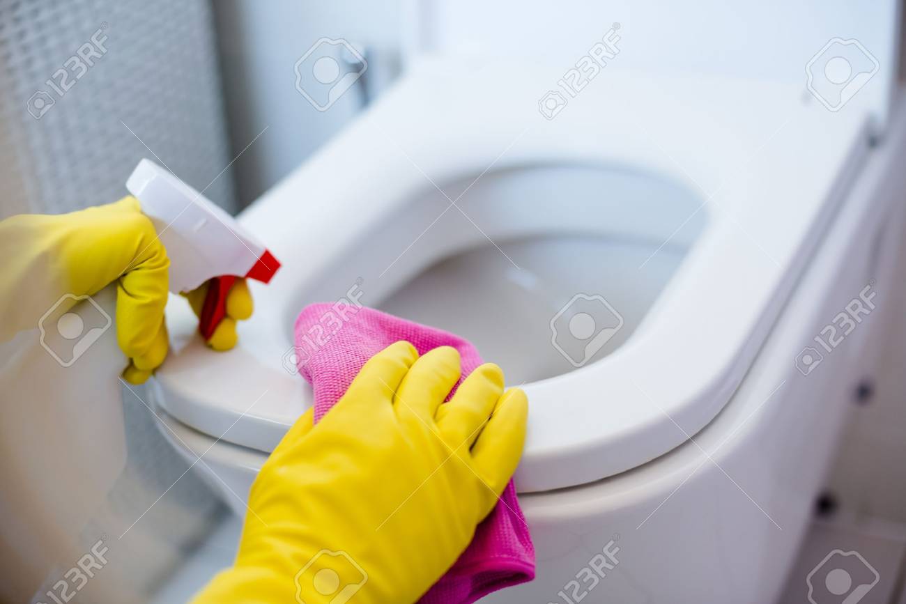 Woman in yellow rubber gloves cleaning toilet with pink cloth - 58617608 Woman in yellow rubber gloves cleaning toilet with pink cloth - 58617608