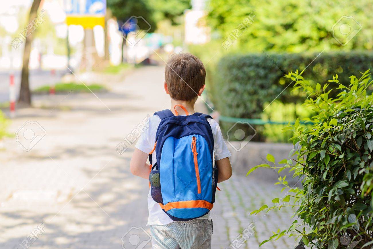 Little 7 years schoolboy going to school. Dressed in white t shirt and shorts. Blue backpack - 61939110 Little 7 years schoolboy going to school. Dressed in white t shirt and shorts. Blue backpack - 61939110