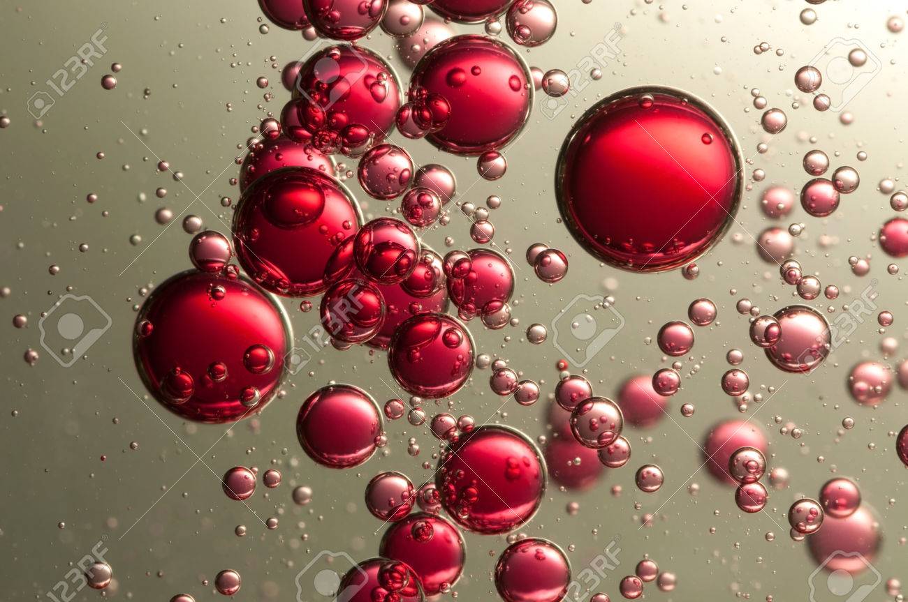 many red fizz bubbles float over a dark background bubbles float