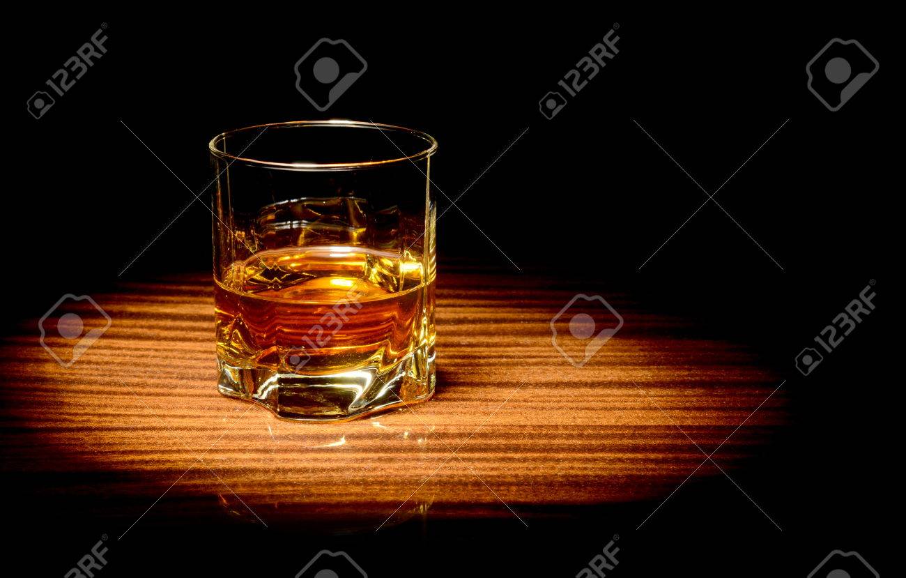 スタジオ ショット グラスにウィスキーの黒に分離されたスポット ライトの点灯 の写真素材 画像素材 Image
