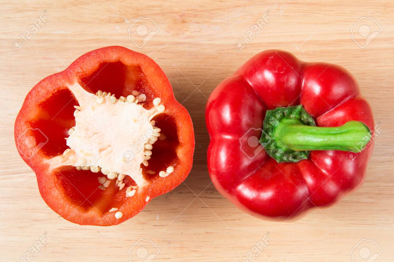 red sweet pepper and a half on a wooden block - 66752085 red sweet pepper and a half on a wooden block - 66752085