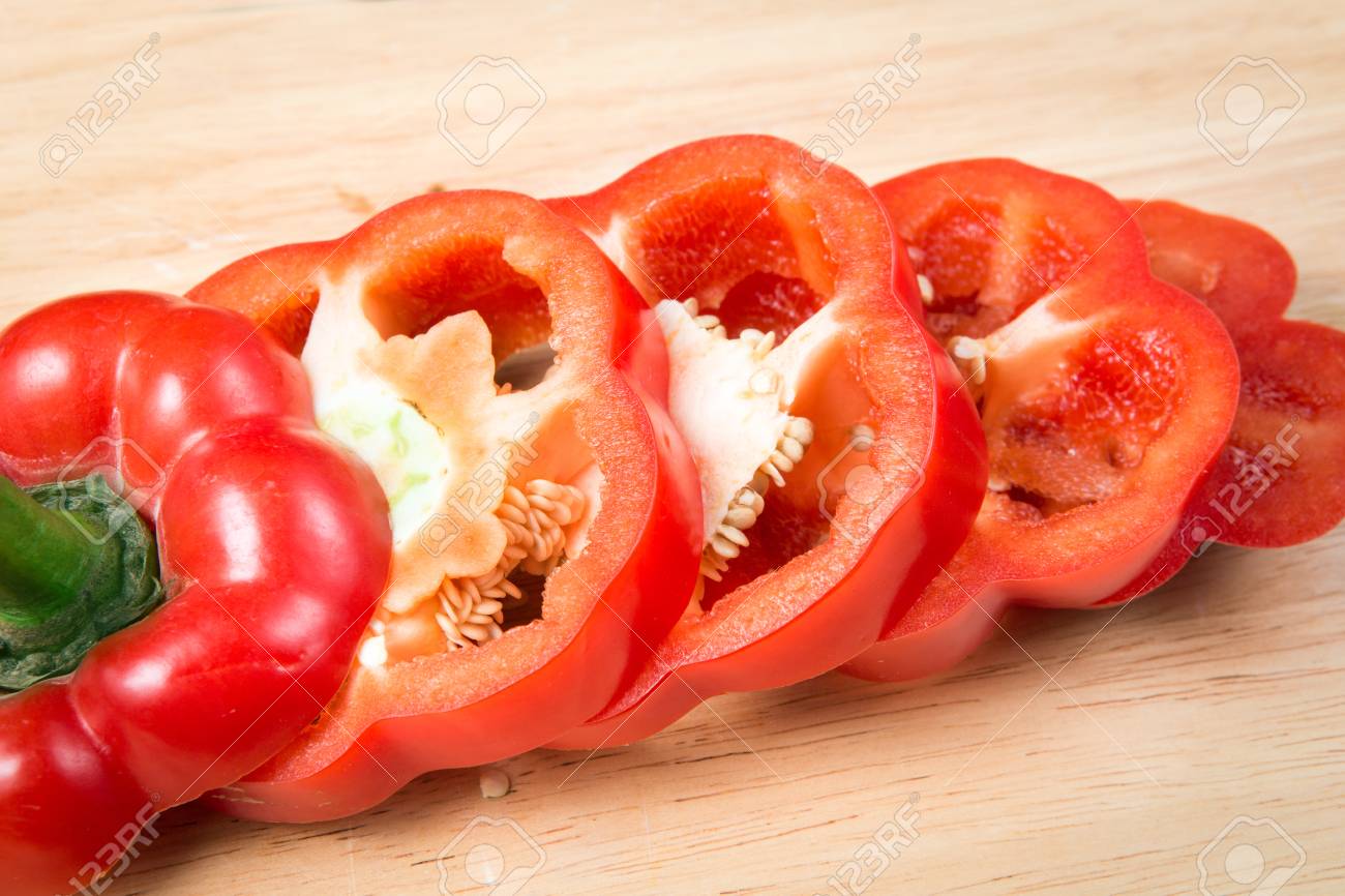 sliced red sweet pepper on a wooden block - 66557608 sliced red sweet pepper on a wooden block - 66557608