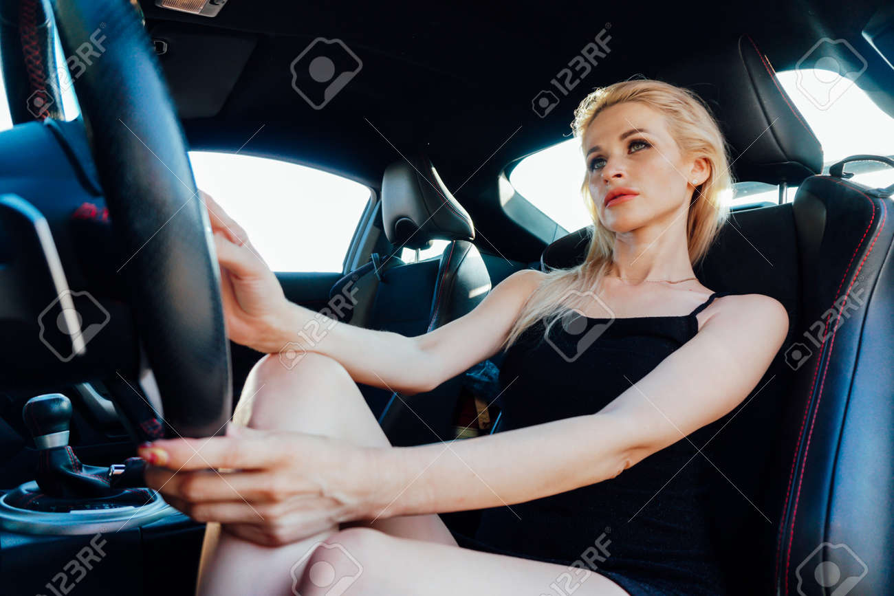 Beautiful female blonde driver behind the wheel of a car - 159442149 Beautiful female blonde driver behind the wheel of a car - 159442149