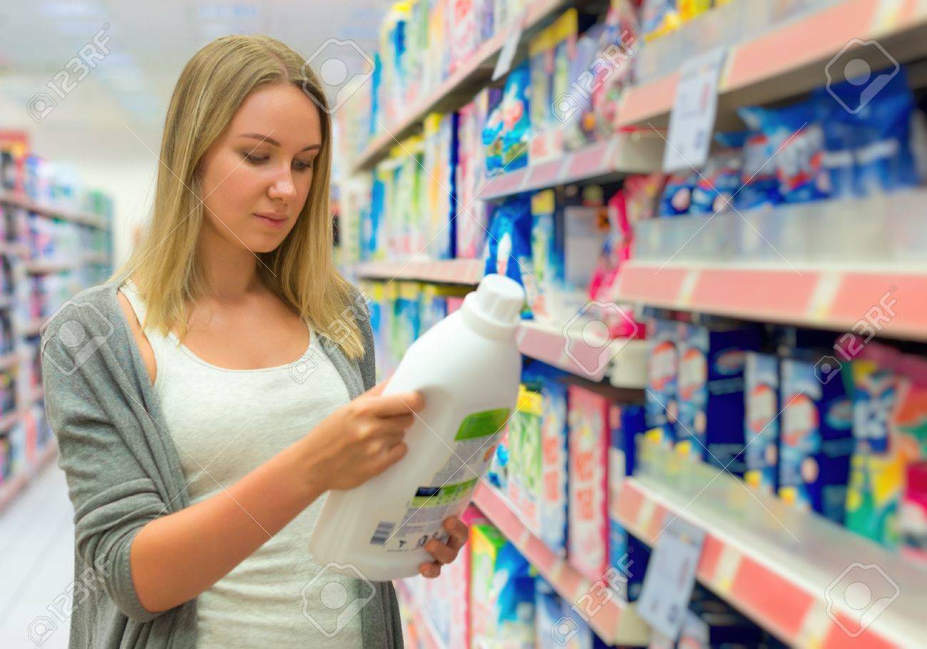 Woman choosing laundry detergent in grocery store. - 48955325 Woman choosing laundry detergent in grocery store. - 48955325