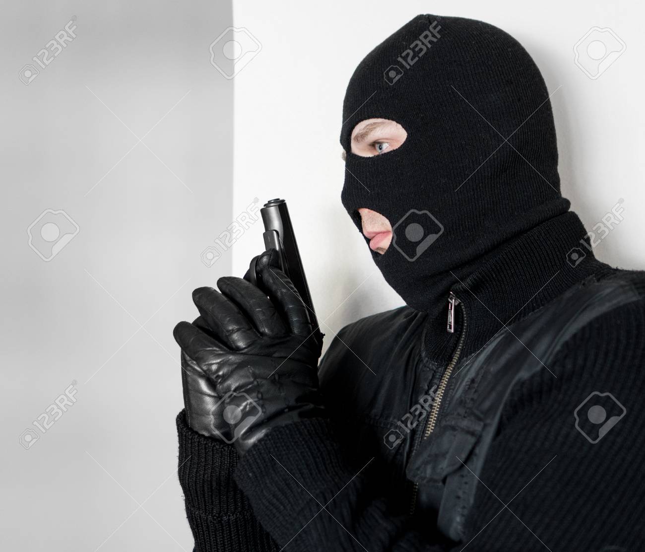 Homme Armé En Cagoule Se Cachant Derrière Un Mur. Banque D'Images et Photos  Libres De Droits. Image 98846433