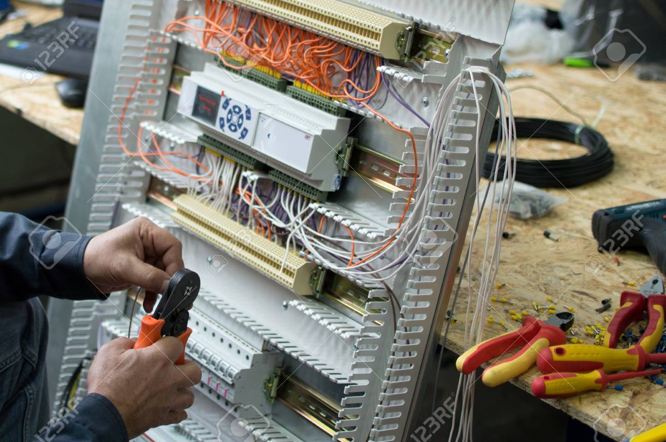 hands of electrical technician assembling low voltage industrial electrical technician