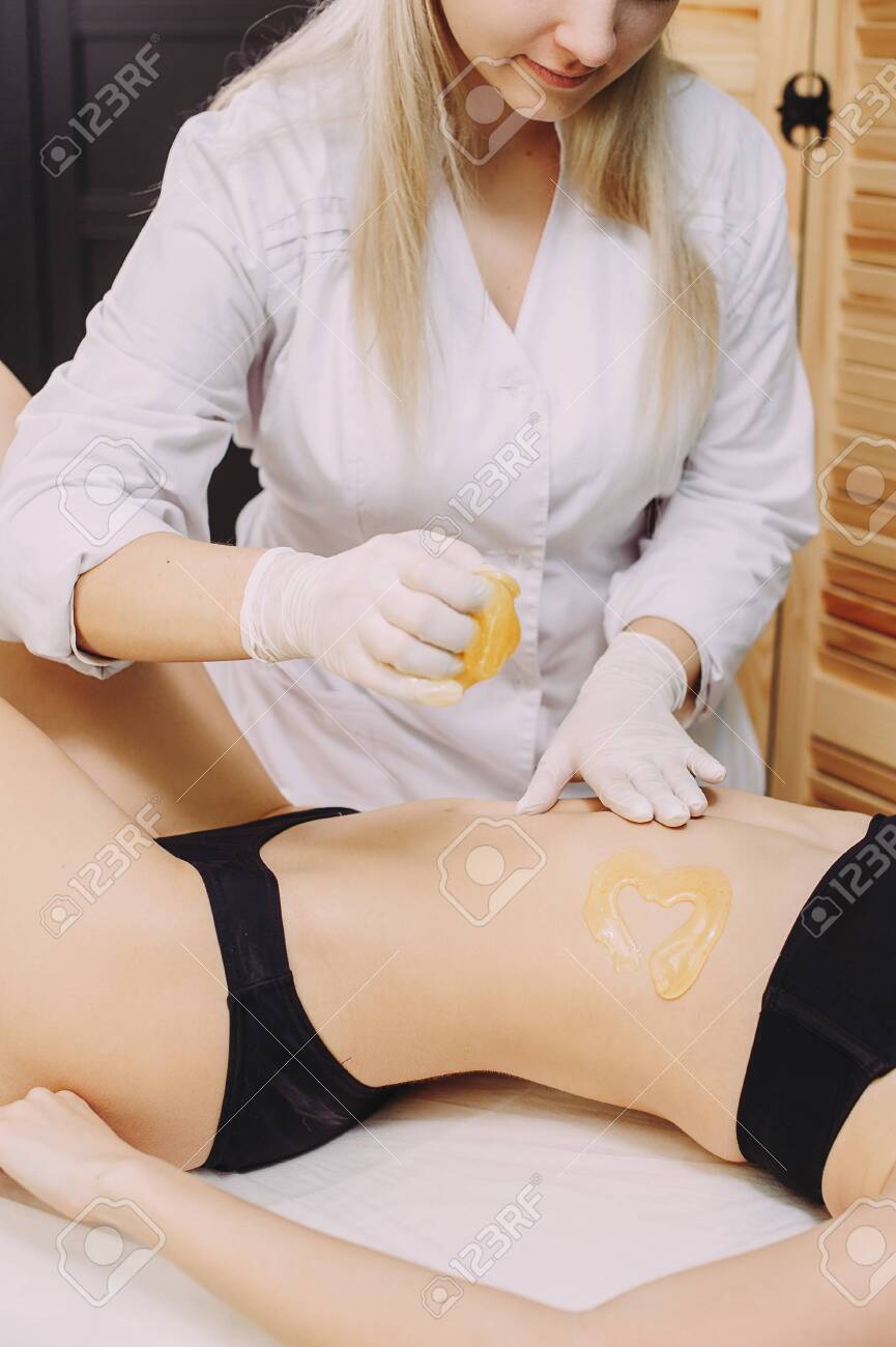 Hair removal at spa luxury studio. Woman legs wax with shugaring. Hot sugar. - 145336723 Hair removal at spa luxury studio. Woman legs wax with shugaring. Hot sugar. - 145336723