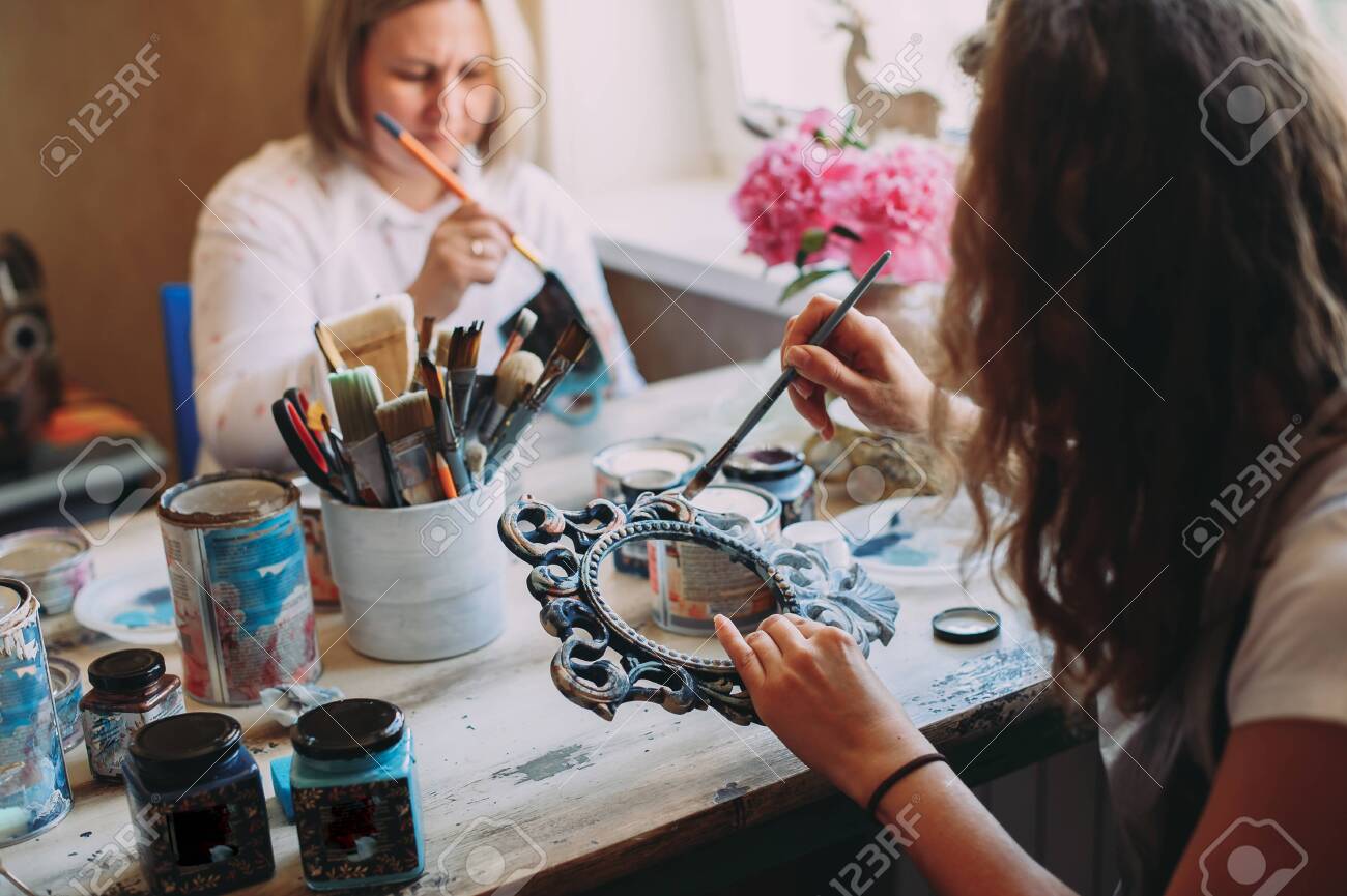 girl paints the frame with a brush. handwork. creation - 145336819 girl paints the frame with a brush. handwork. creation - 145336819