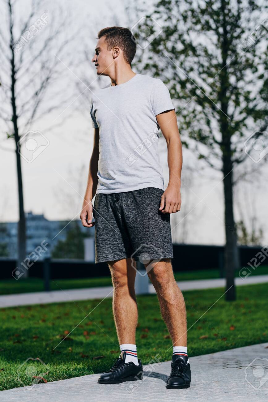 A man in shorts goes in for sports in a park in nature and a model running sneakers - 153814986 A man in shorts goes in for sports in a park in nature and a model running sneakers - 153814986