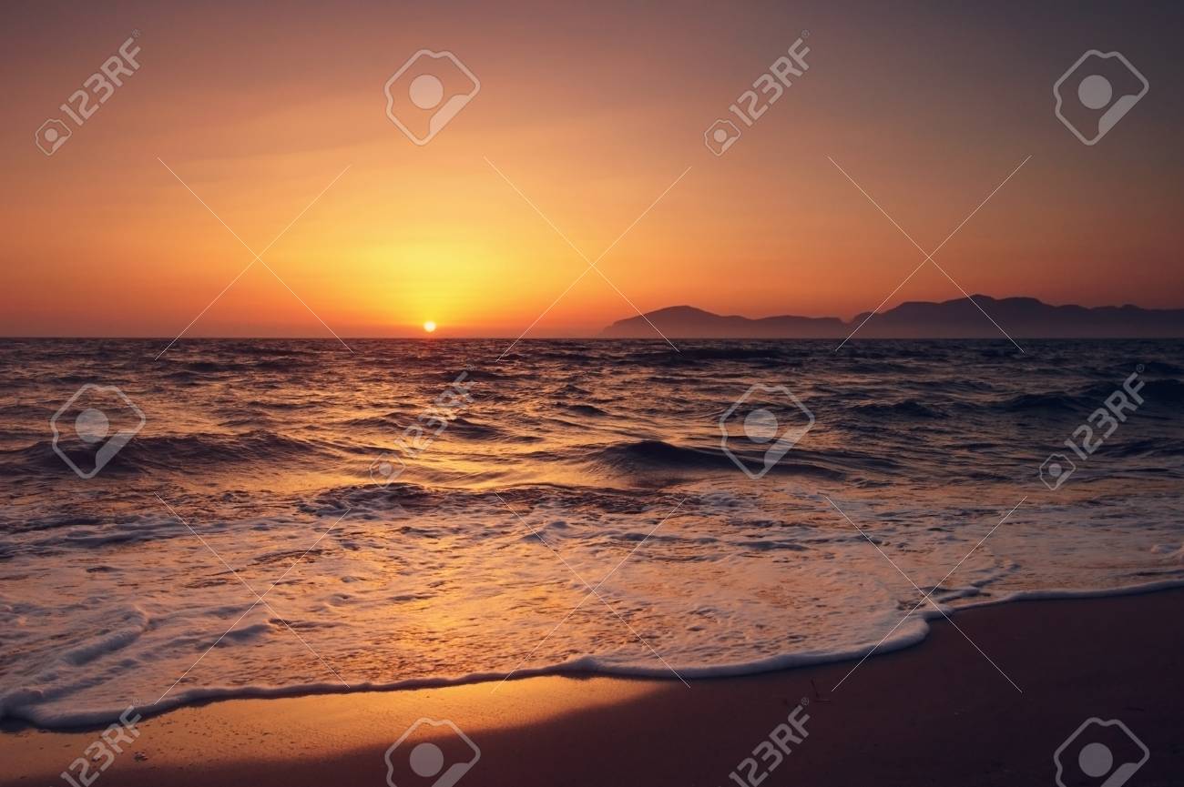 砂浜のビーチから水平線を山で表示します 海海岸の夕日 の写真素材 画像素材 Image