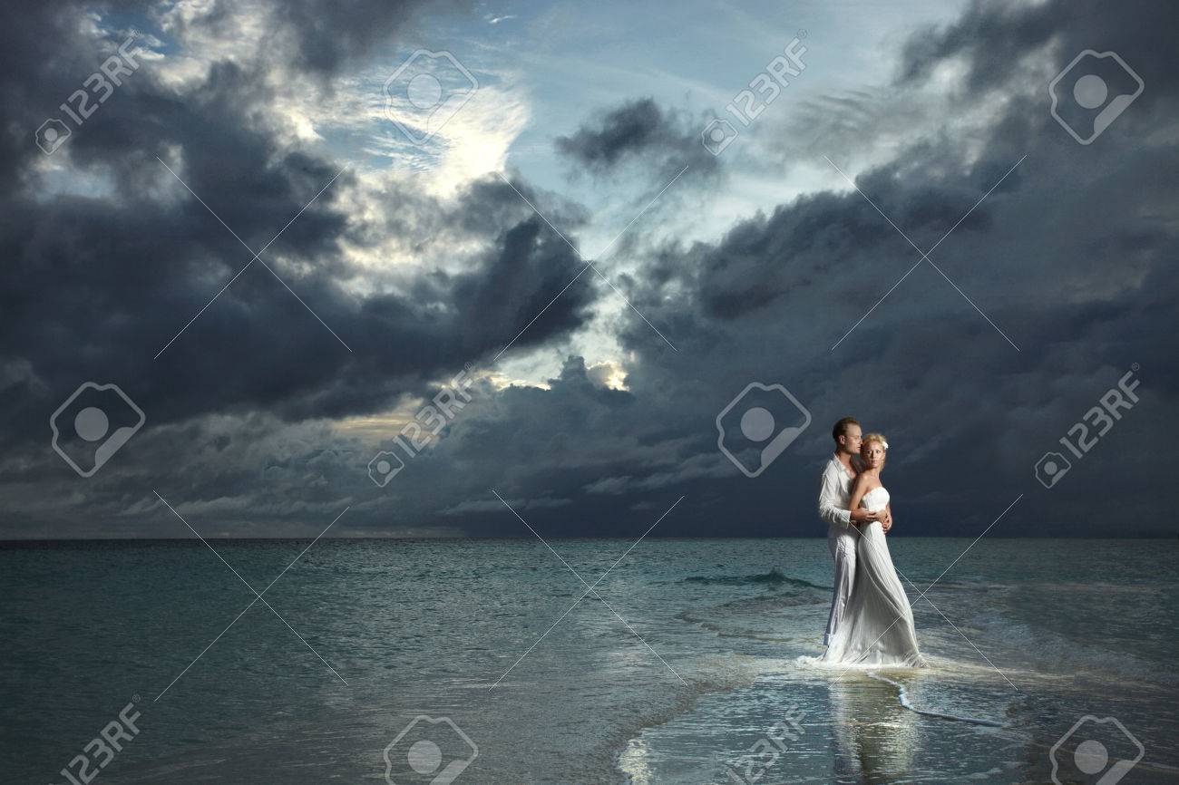 結婚式のカップル 花嫁と花婿の性的な抱きしめる夕焼け雲を脅迫の下で立っています 壮大な夜のミステリー の写真素材 画像素材 Image