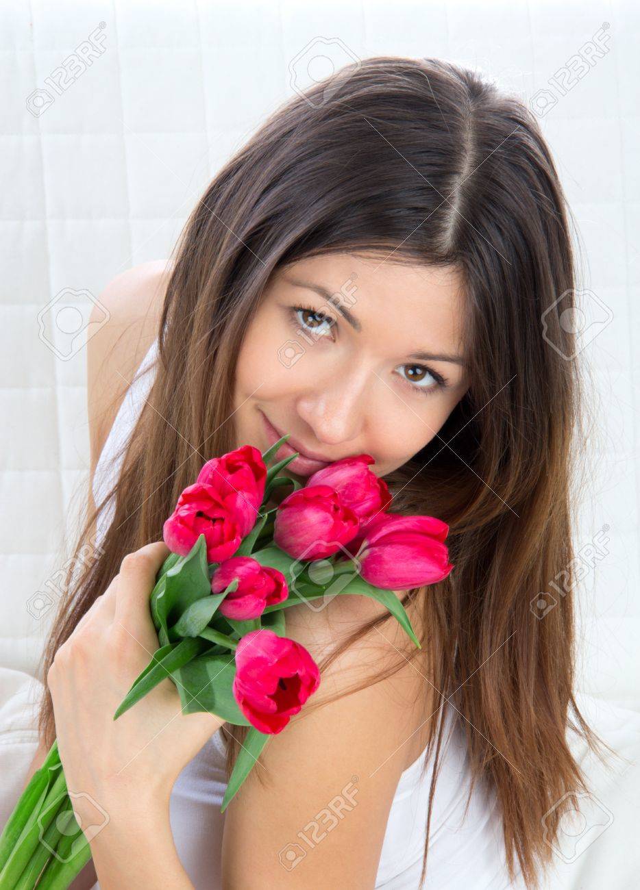 Belle Jeune Femme Avec Bouquet De Tulipes Rouges Fleurs Assis Sur Un Canapé Souriante