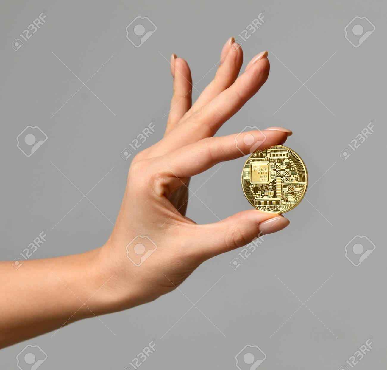 Hand Hold Gold Bitcoin Cryptocurrency On Grey Background. Physical Bit  Coin. Digital Currency Back Side Stock Photo, Picture and Royalty Free  Image. Image 93856097.