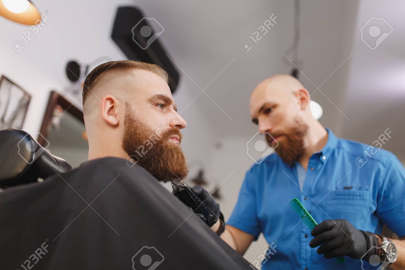 Male Professional Hairdresser Serving Client By Clipper Ginger