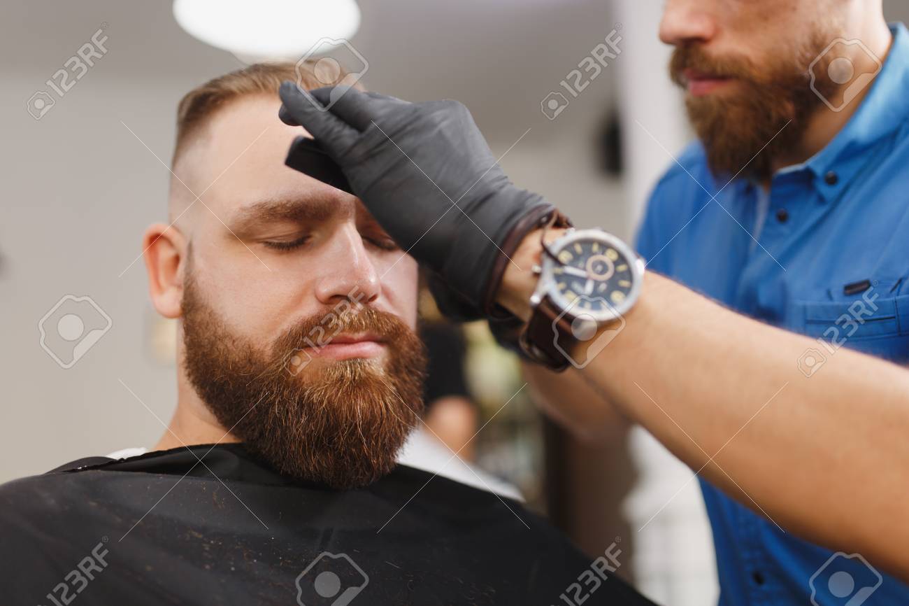 Male Professional Hairdresser Serving Client Shearing Eyebrows