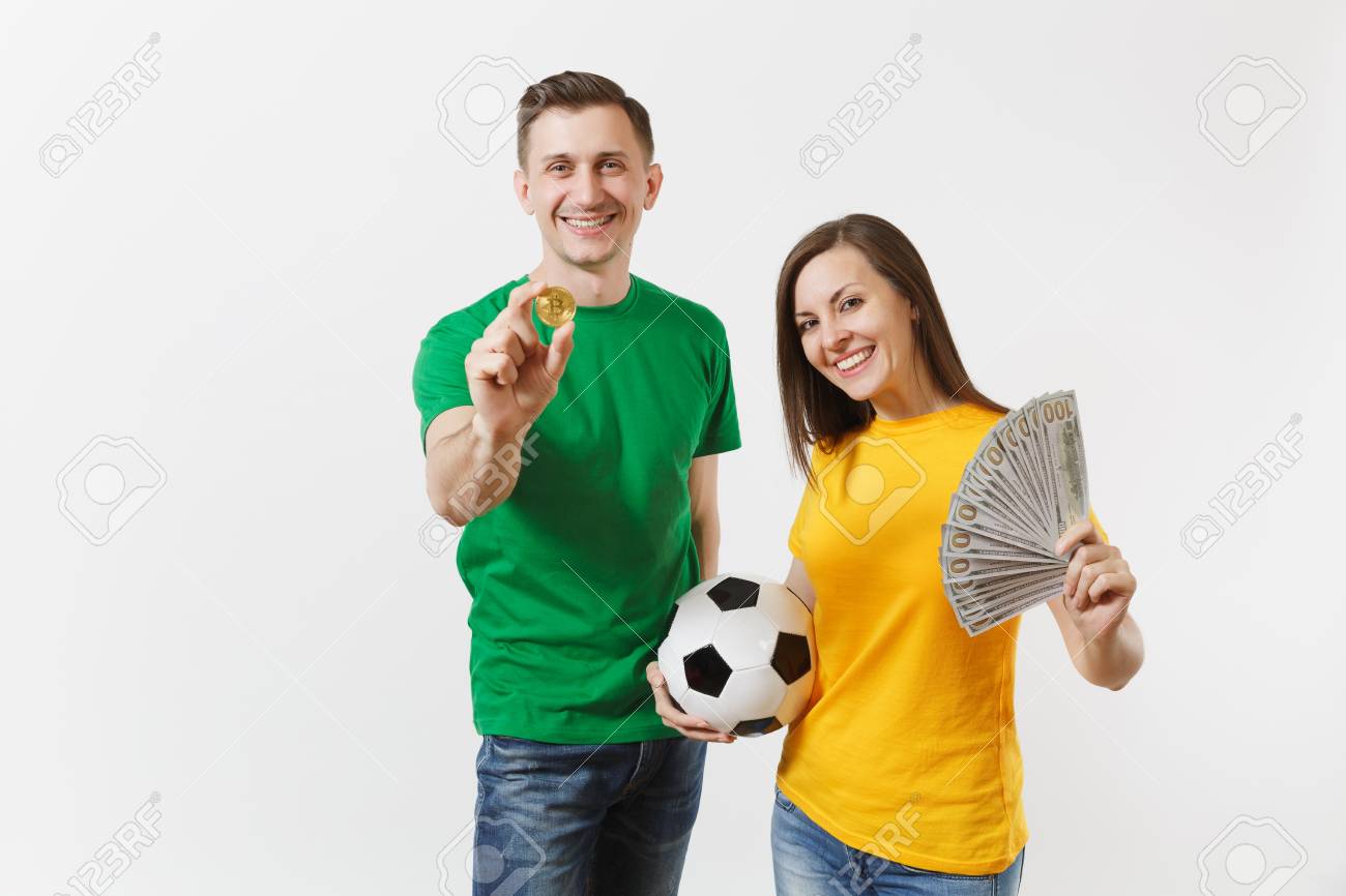 笑顔の若いカップルの女性の男、黄緑色のTシャツのサッカーファンは、サッカーボールビットコイン、白い背景で隔離の黄金のコインでサポートチームを応援します。スポーツ家族のレジャーライフスタイルのコンセプト。の写真素材・画像素材  Image 103476596