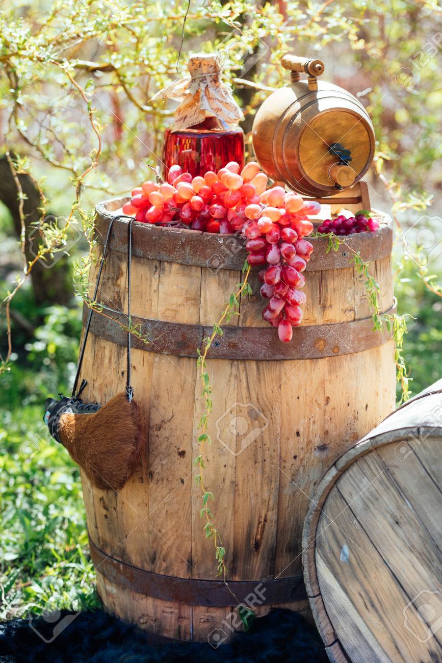 weinfassmöbel im freien altes weinfass altes hölzernes weinfass mit flasche wein und trauben auf ihm hochzeitsdekorationen im freien standard hölzernes mit und auf ihm weinfassmöbel im freien altes weinfass altes hölzernes weinfass mit flasche wein und trauben auf ihm hochzeitsdekorationen im freien standard hölzernes mit und auf ihm