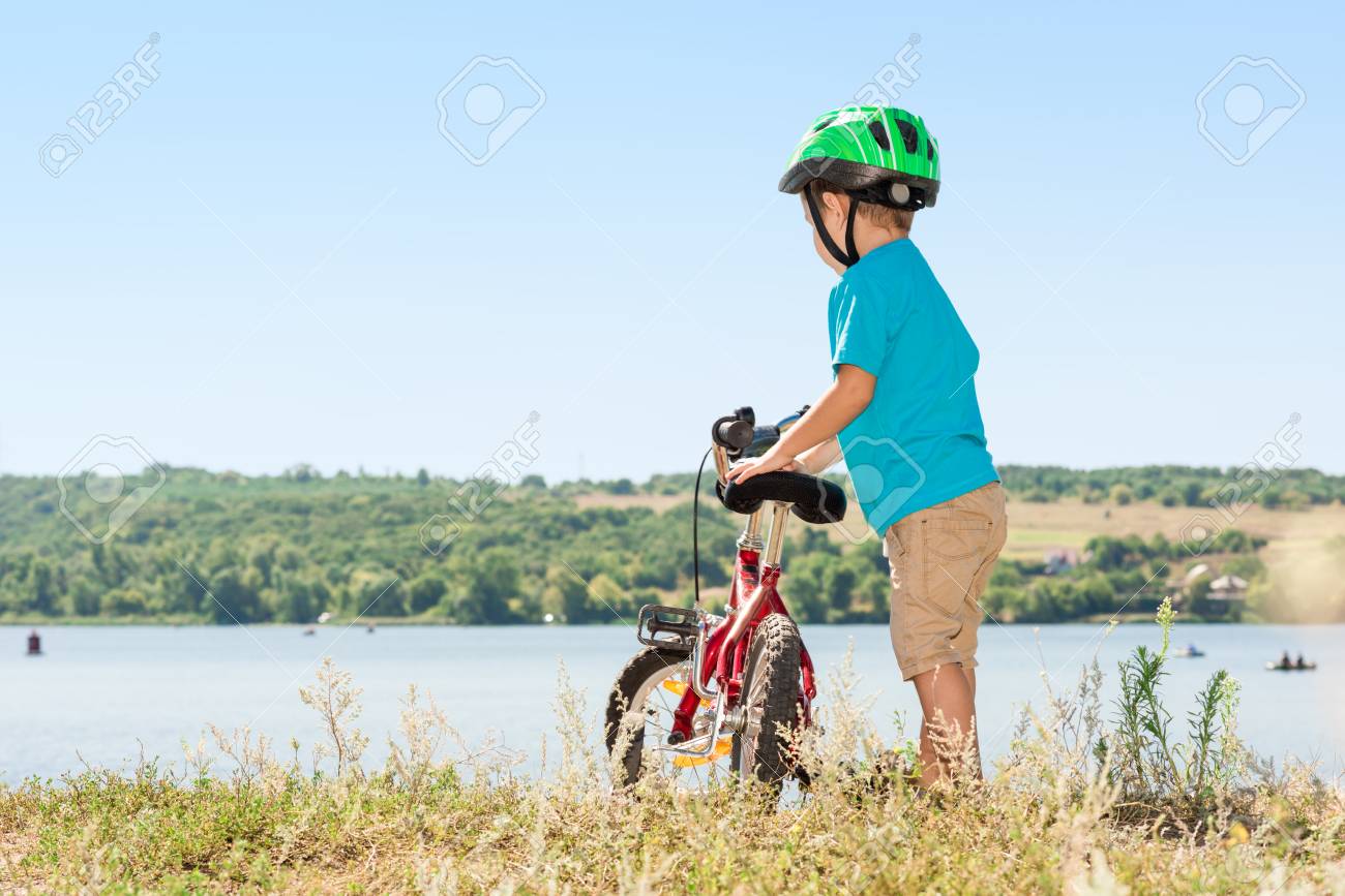 子供は自転車に乗る 川の土手を自転車と子供 森で自転車に乗ってヘルメットの子供します 美しい赤ちゃん トーンのイメージ の写真素材 画像素材 Image