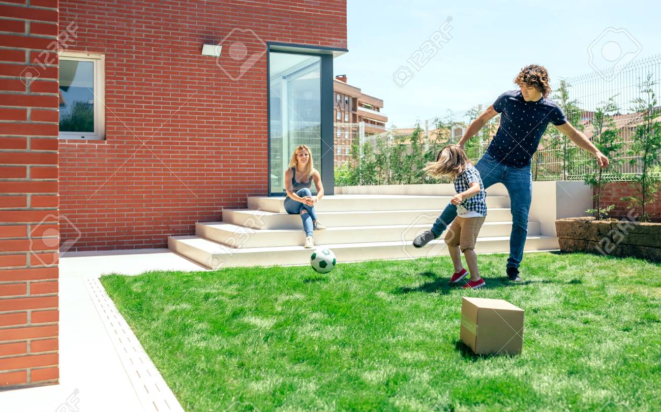 夫と息子が庭でサッカーを見て母 の写真素材 画像素材 Image