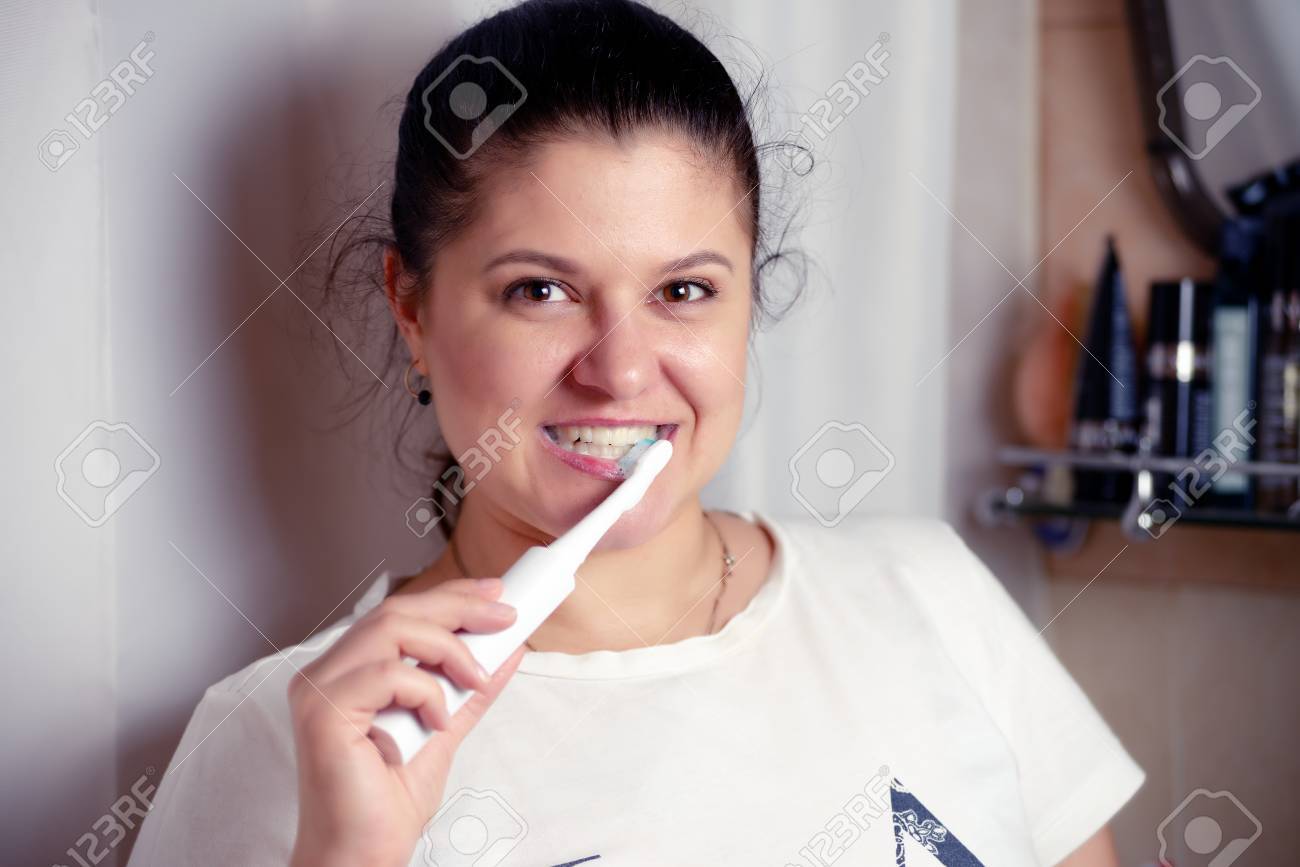 Giovane Donna Spazzole Denti In Bagno Una Scopa Elettrica Foto ... Giovane Donna Spazzole Denti In Bagno Una Scopa Elettrica Foto ...