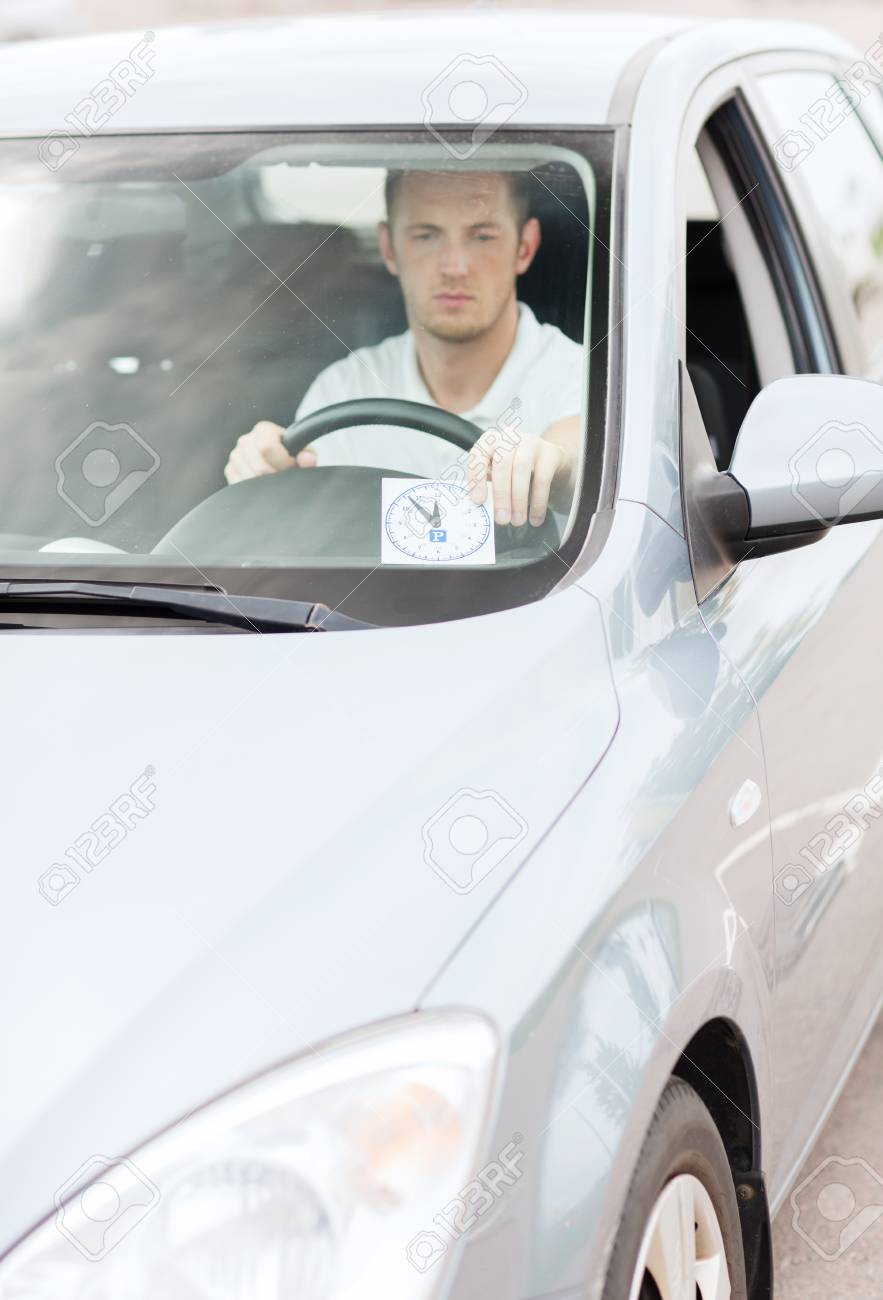 フロント ガラスの下で車のダッシュ ボード上の時計が輸送 車両のコンセプト 駐車場配置する男 の写真素材 画像素材 Image
