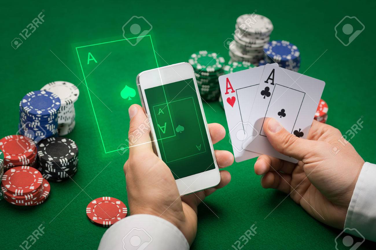 Casino, Online Gambling, Technology And People Concept - Close Up Of Poker Player With Playing Cards, Smartphone And Chips At Green Casino Table Stock Photo, Picture And Royalty Free Image. Image 35562878.