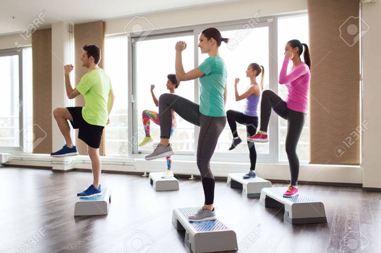 fitness, sport, training, aerobics and people concept - group of people working out with steppers in gym - 45880749 fitness, sport, training, aerobics and people concept - group of people working out with steppers in gym - 45880749