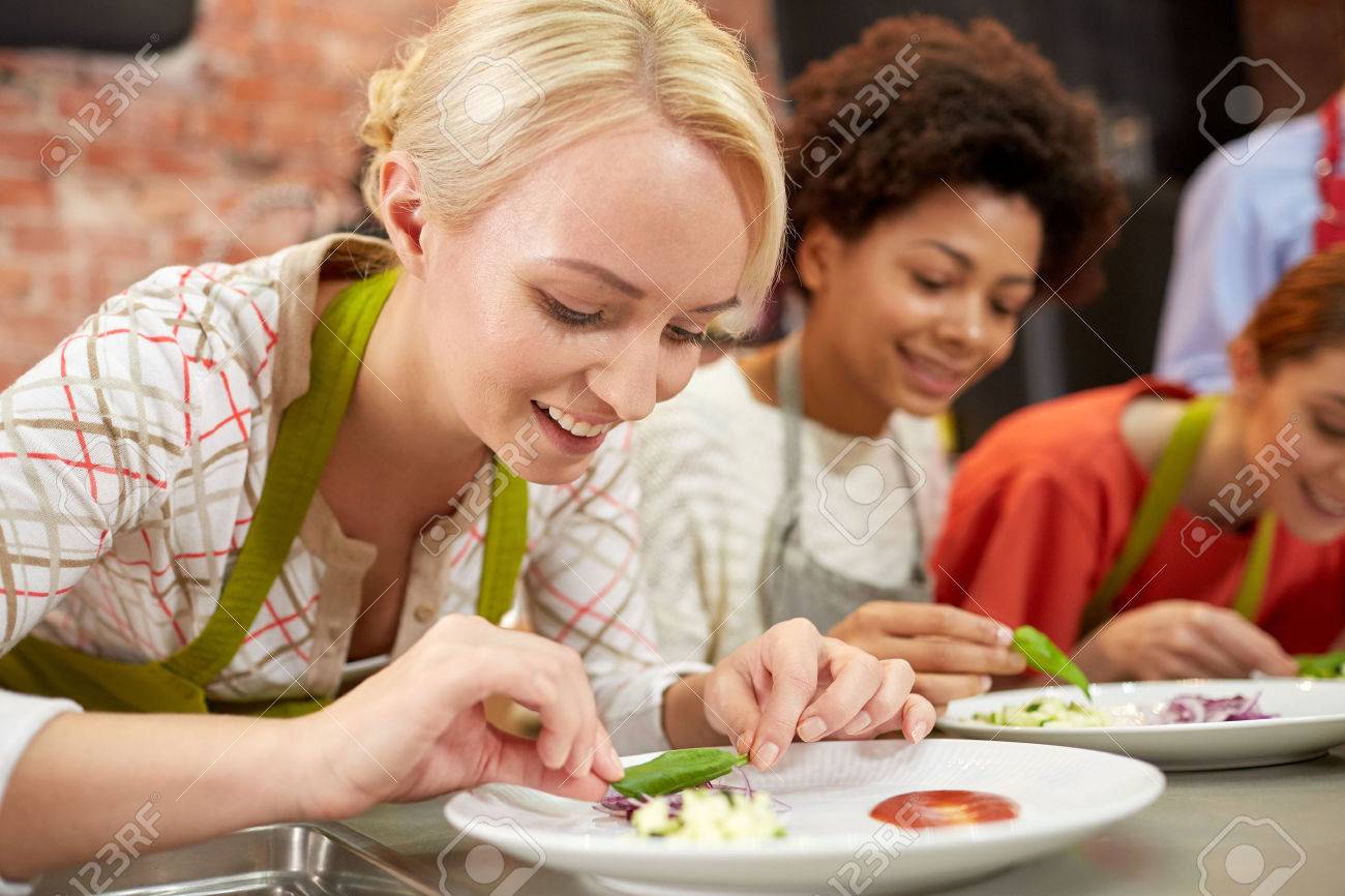 Kochkurs Freundschaft Essen Und Menschen Konzept Gluckliche Frauen Das Kochen Und Dekorieren Platten Mit Geschirr In Der Kuche Lizenzfreie Fotos Bilder Und Stock Fotografie Image