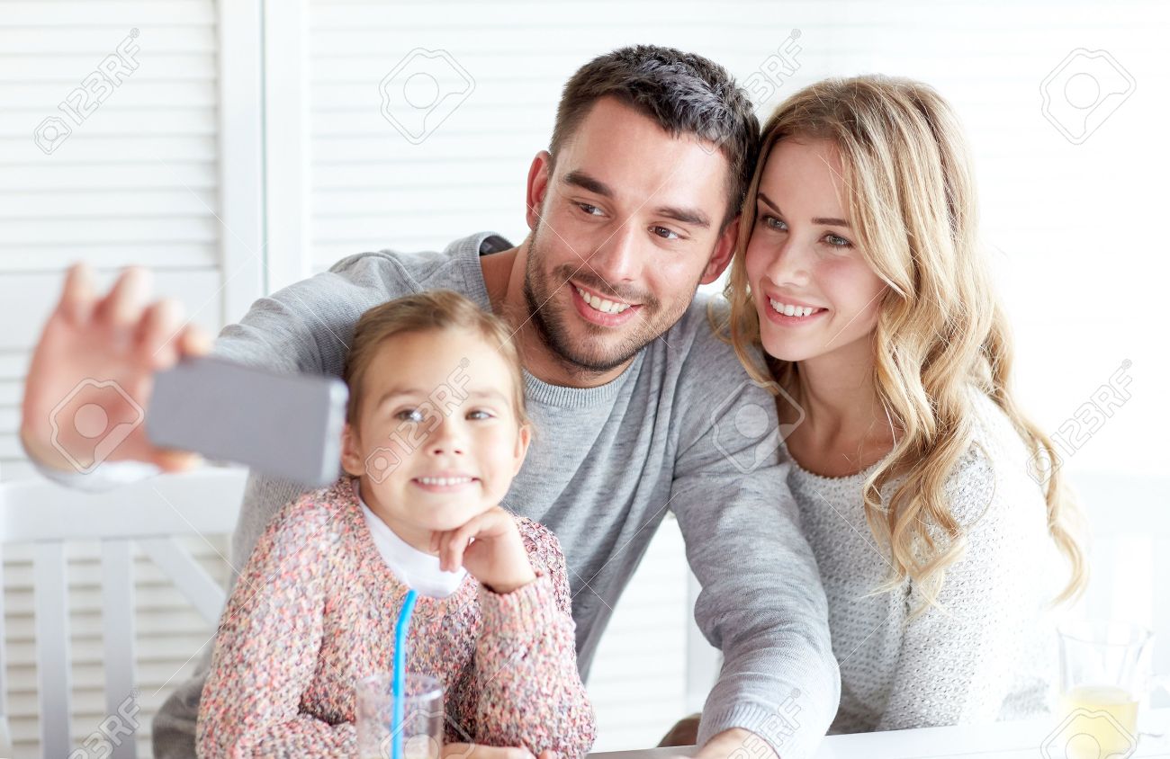 family, parenthood, technology and people concept - happy mother, father and little girl having dinner and taking selfie by smartphone at restaurant - 48790158 family, parenthood, technology and people concept - happy mother, father and little girl having dinner and taking selfie by smartphone at restaurant - 48790158