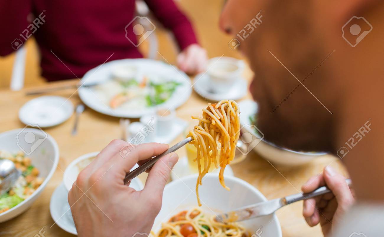 people, leisure and food concept - close up man eating pasta for dinner at restaurant or home - 50278031 people, leisure and food concept - close up man eating pasta for dinner at restaurant or home - 50278031