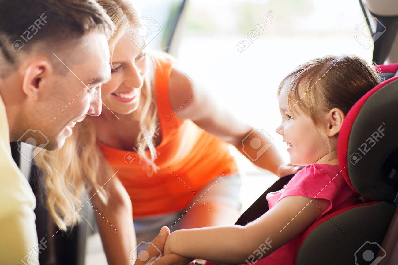 family, transport, safety, road trip and people concept - happy parents talking to little girl in baby car seat - 50370378 family, transport, safety, road trip and people concept - happy parents talking to little girl in baby car seat - 50370378