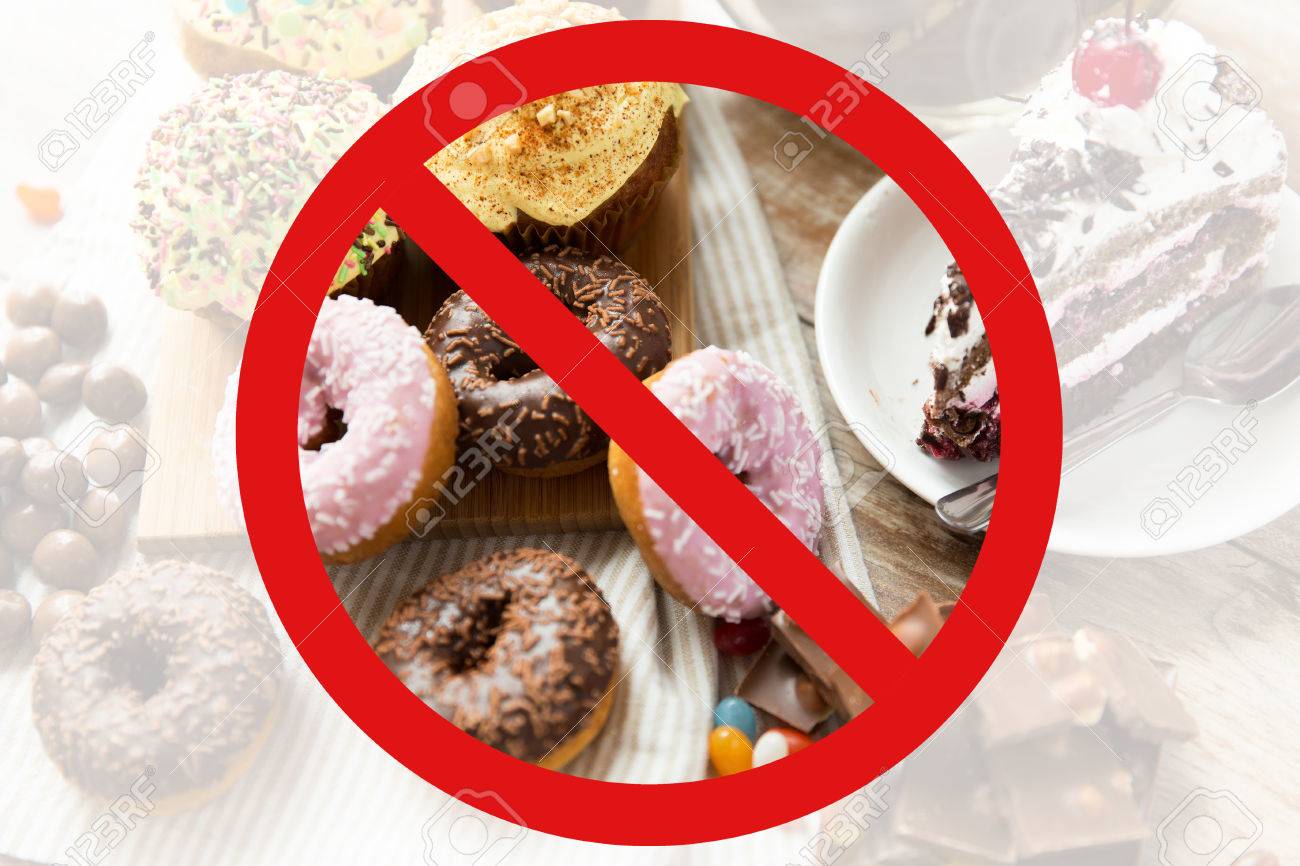 fast food, low carb diet, fattening and unhealthy eating concept - close up of glazed donuts, cakes and chocolate sweets behind no symbol or circle-backslash prohibition sign - 52917092 fast food, low carb diet, fattening and unhealthy eating concept - close up of glazed donuts, cakes and chocolate sweets behind no symbol or circle-backslash prohibition sign - 52917092