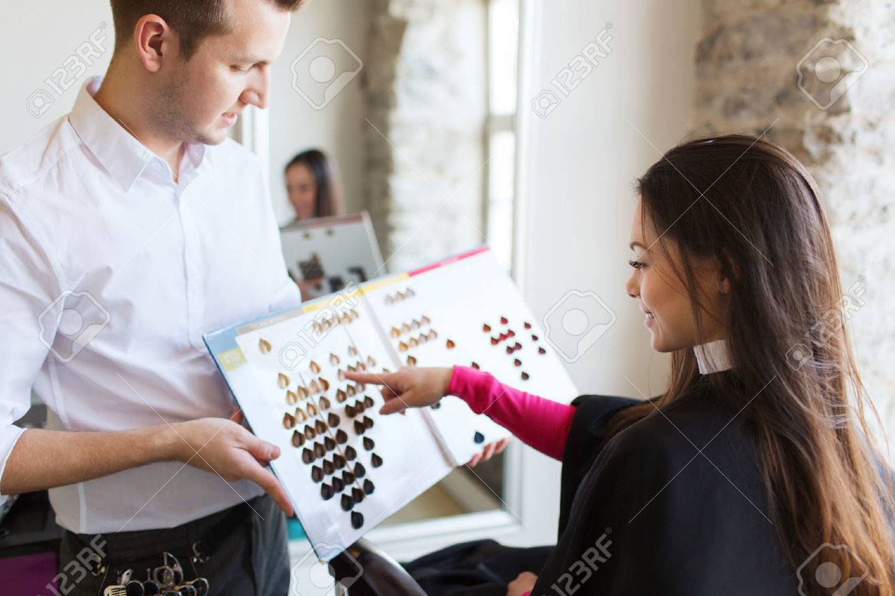 beauty, hair dyeing and people concept - happy young woman with hairdresser choosing hair color from palette samples at salon - 53434374 beauty, hair dyeing and people concept - happy young woman with hairdresser choosing hair color from palette samples at salon - 53434374