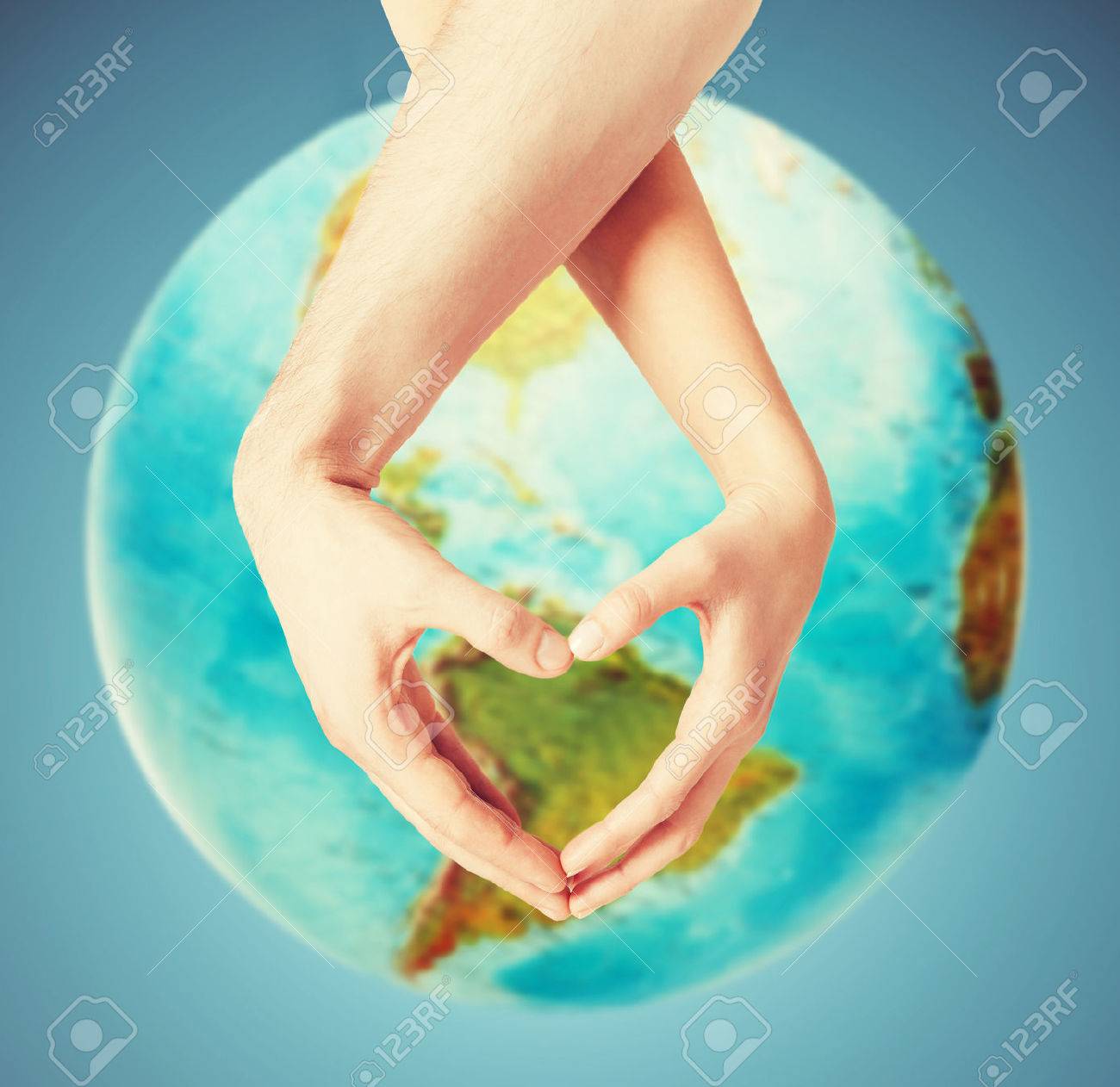 people, peace, love, life and environmental concept - close up of human hands showing heart shape gesture over earth globe and blue background - 54407059 people, peace, love, life and environmental concept - close up of human hands showing heart shape gesture over earth globe and blue background - 54407059