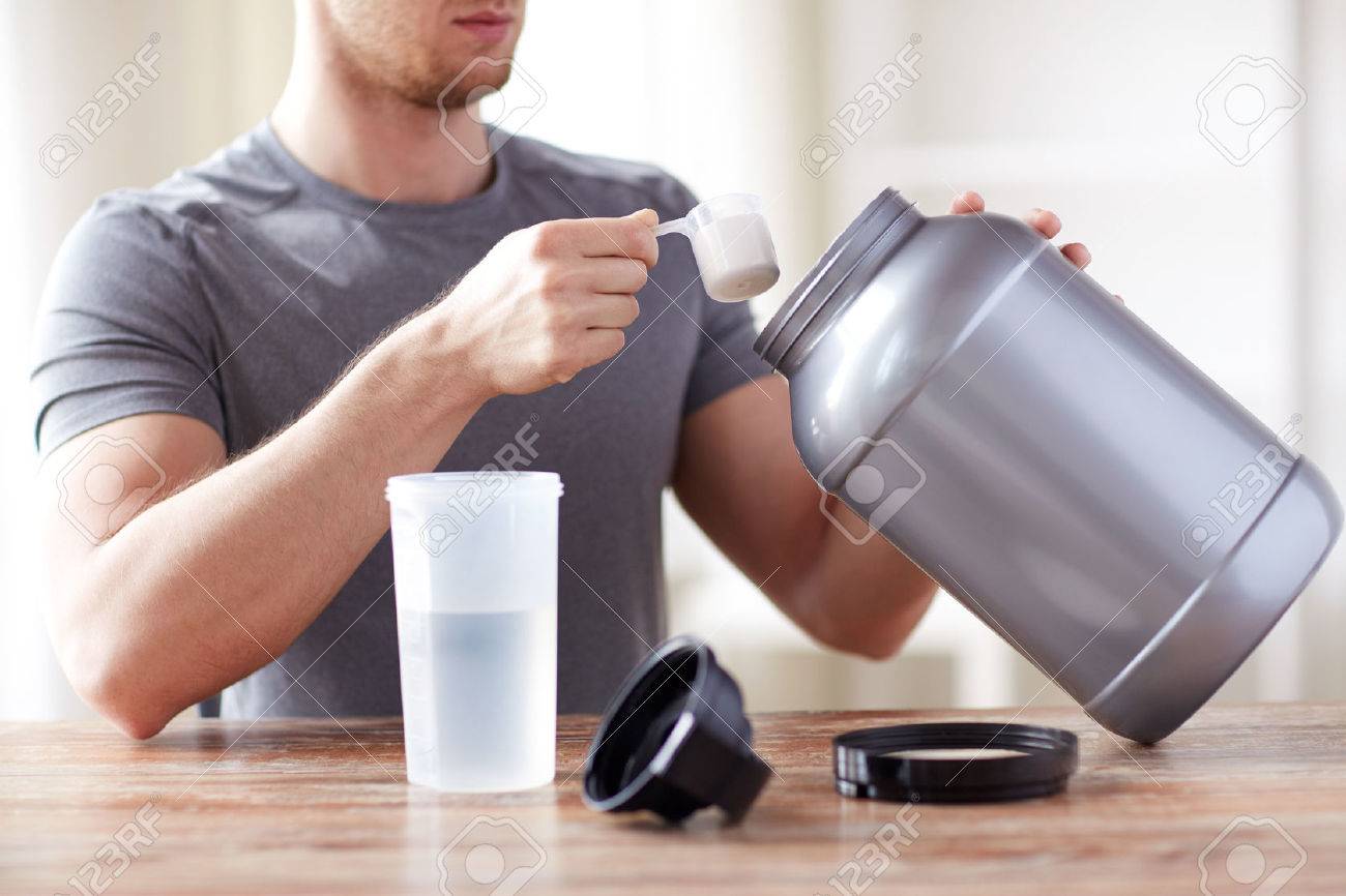 sport, fitness, healthy lifestyle and people concept - close up of man with jar and bottle preparing protein shake - 54776175 sport, fitness, healthy lifestyle and people concept - close up of man with jar and bottle preparing protein shake - 54776175