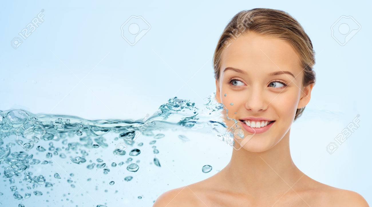 beauty, people and health concept - smiling young woman face and shoulders over water splash and blue background - 58526770 beauty, people and health concept - smiling young woman face and shoulders over water splash and blue background - 58526770