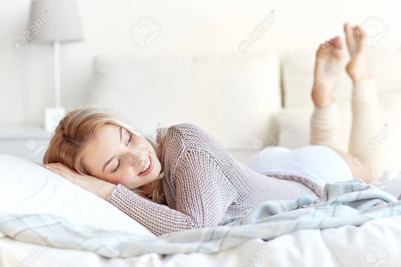 rest sleeping comfort and people concept happy young woman