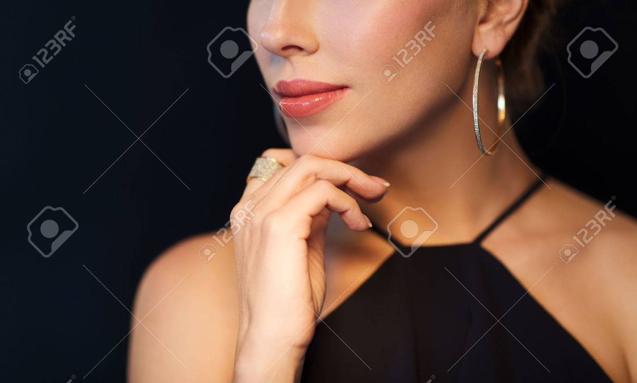 people, luxury, jewelry and fashion concept - beautiful woman in black wearing diamond earring and ring over dark background - 63062871 people, luxury, jewelry and fashion concept - beautiful woman in black wearing diamond earring and ring over dark background - 63062871