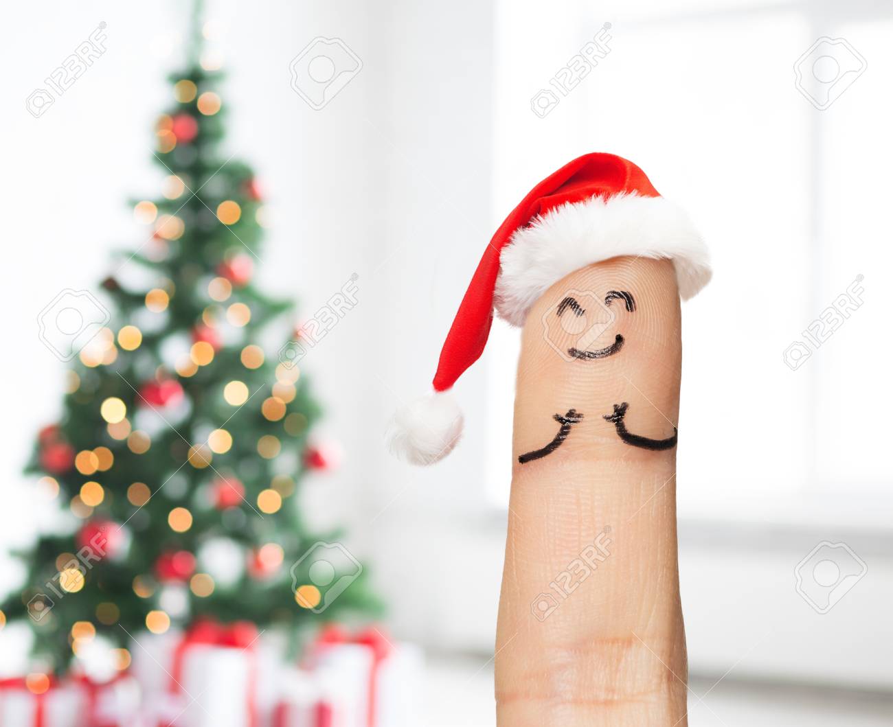 Holidays, Christmas And Body Parts Concept - Close Up Of One Finger In  Santa Hat Over Tree Lights Background Stock Photo, Picture And Royalty Free  Image. Image 64678333.