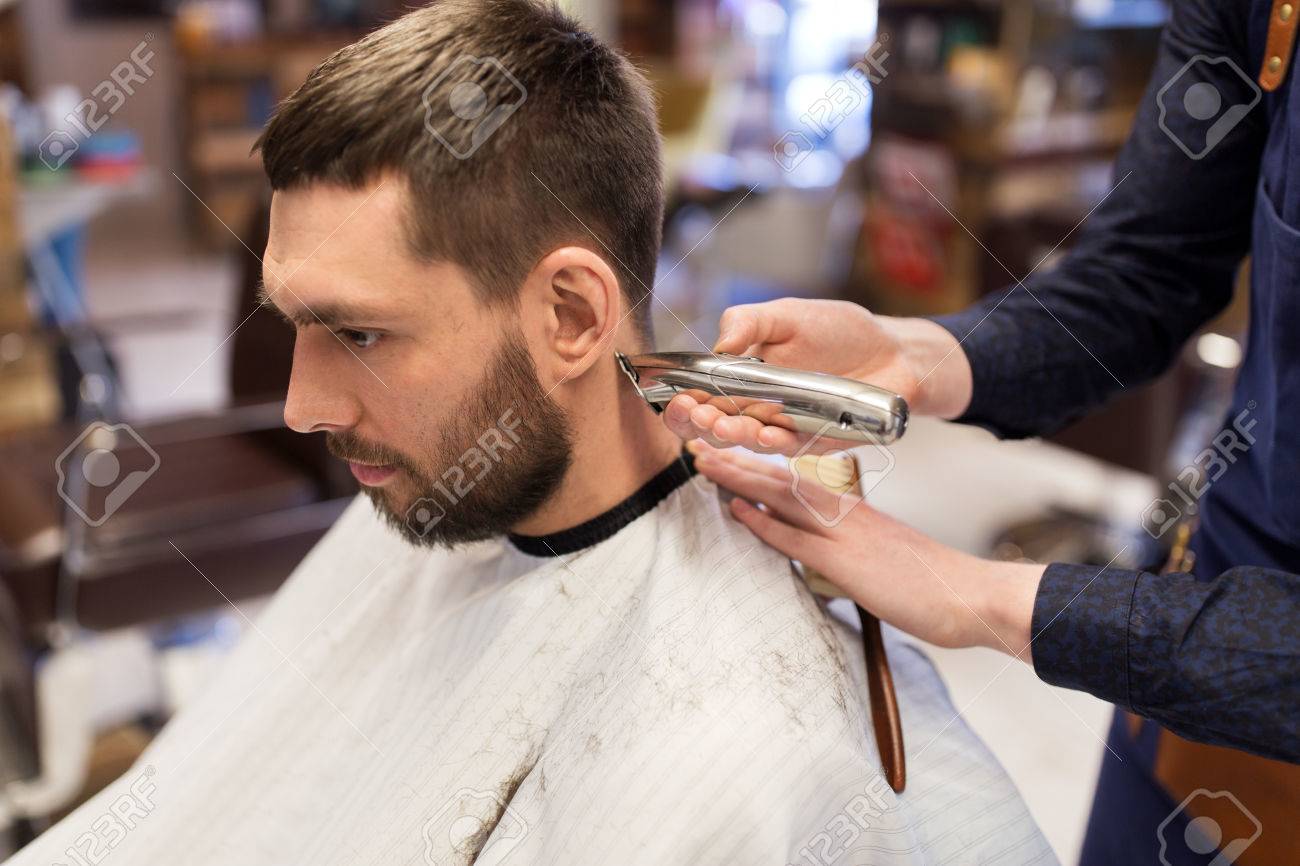 Man And Barber Hands With Trimmer Cutting Hair Stock Photo