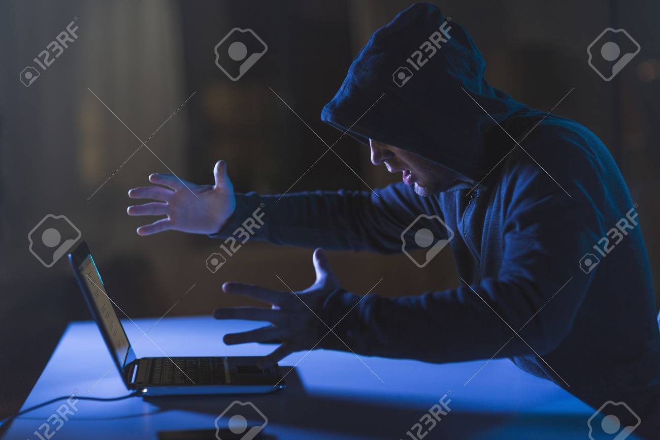 暗い部屋でラップトップコンピュータと怒っているハッカーの写真素材・画像素材 Image 100740218