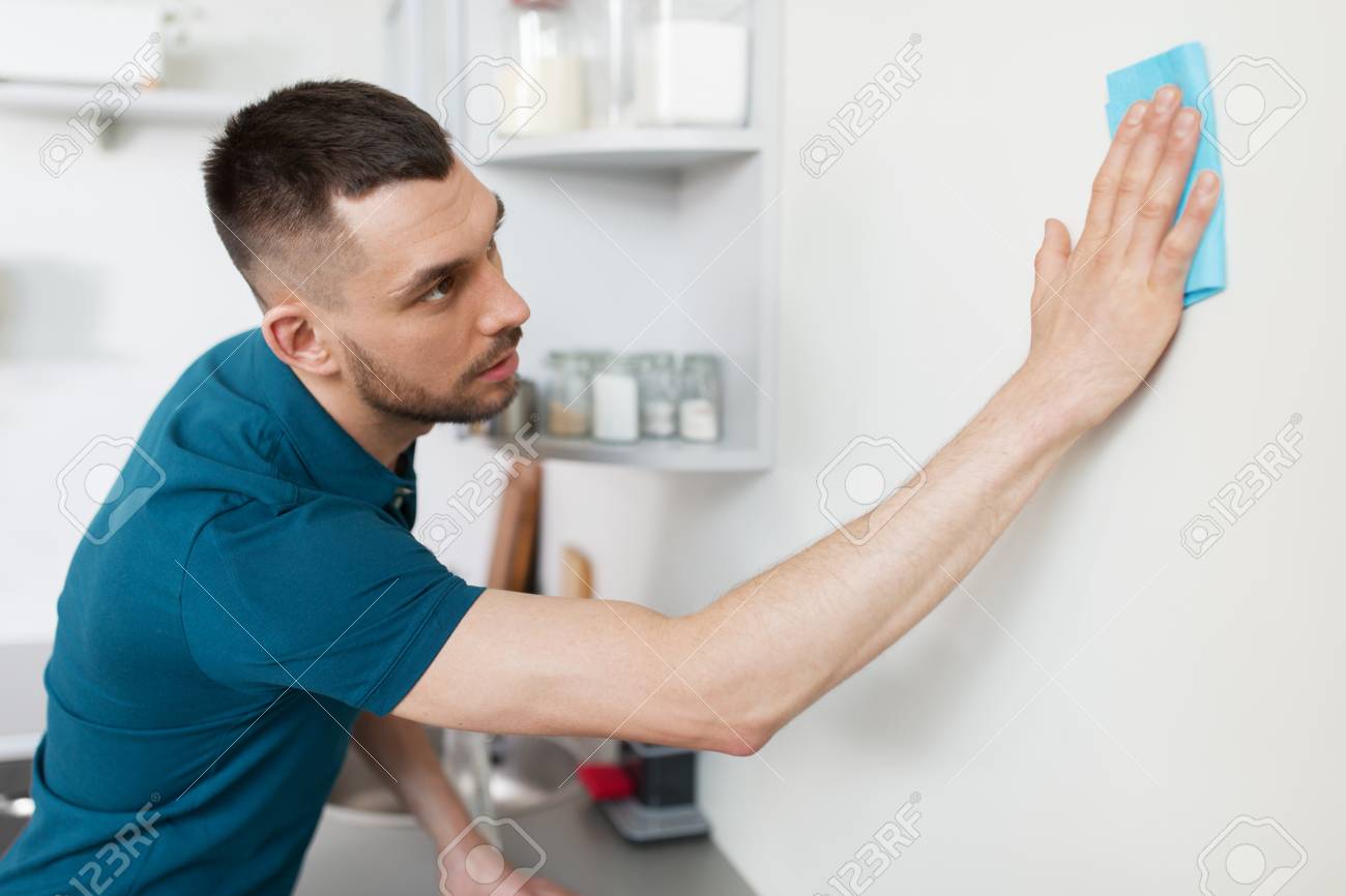 man with rag cleaning wall at home kitchen - 101793864 man with rag cleaning wall at home kitchen - 101793864