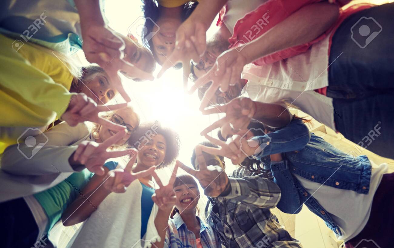 Education, friendship, gesture, victory and people concept - Group of happy international students or friends standing in circle and showing peace or v sign - 120888474 Education, friendship, gesture, victory and people concept - Group of happy international students or friends standing in circle and showing peace or v sign - 120888474