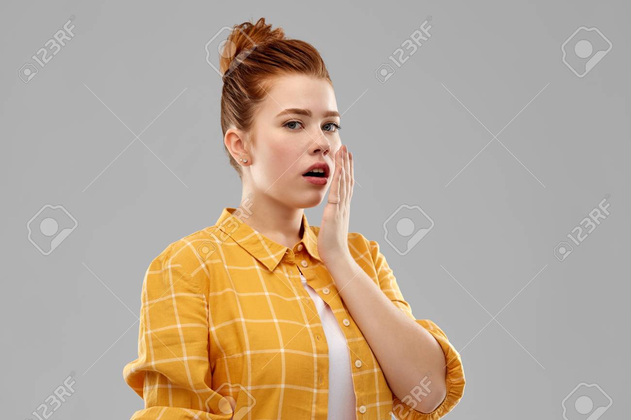 emotion, expression and people concept - red haired teenage girl in checkered shirt covering mouth by hands over grey background - 121162711 emotion, expression and people concept - red haired teenage girl in checkered shirt covering mouth by hands over grey background - 121162711