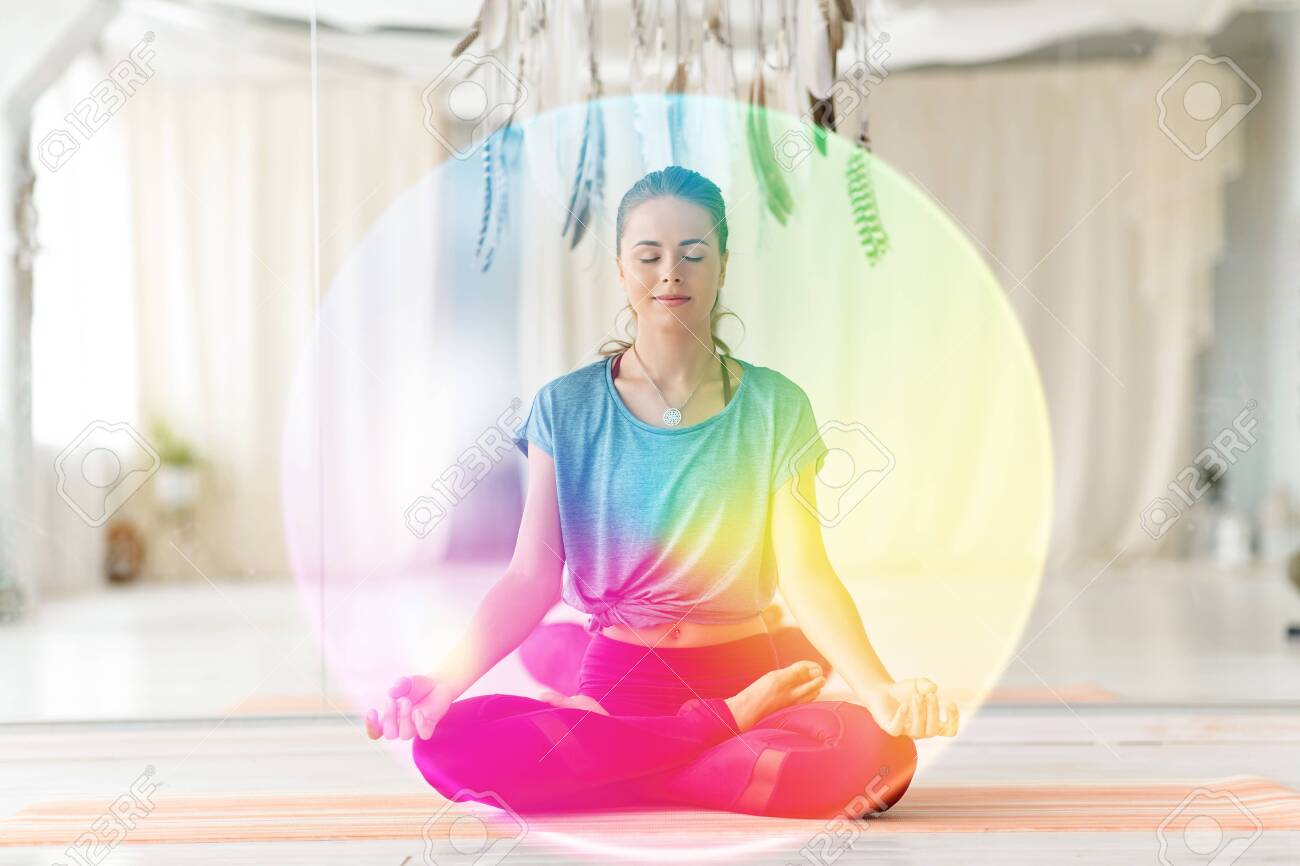 Woman meditating in lotus pose at yoga studio - 121996496 Woman meditating in lotus pose at yoga studio - 121996496