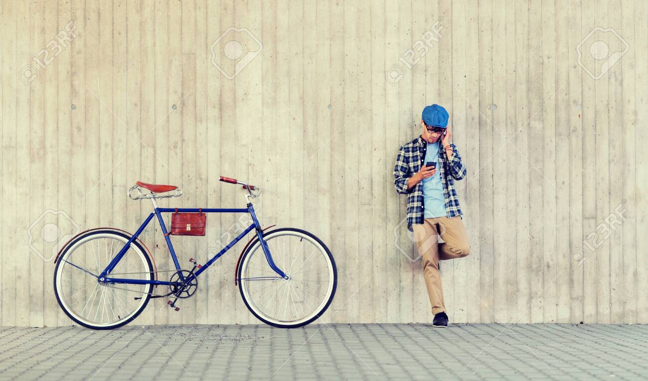 people, style, technology, leisure and lifestyle - young hipster man in earphones with smartphone and fixed gear bike listening to music at city street wall - 122209015 people, style, technology, leisure and lifestyle - young hipster man in earphones with smartphone and fixed gear bike listening to music at city street wall - 122209015