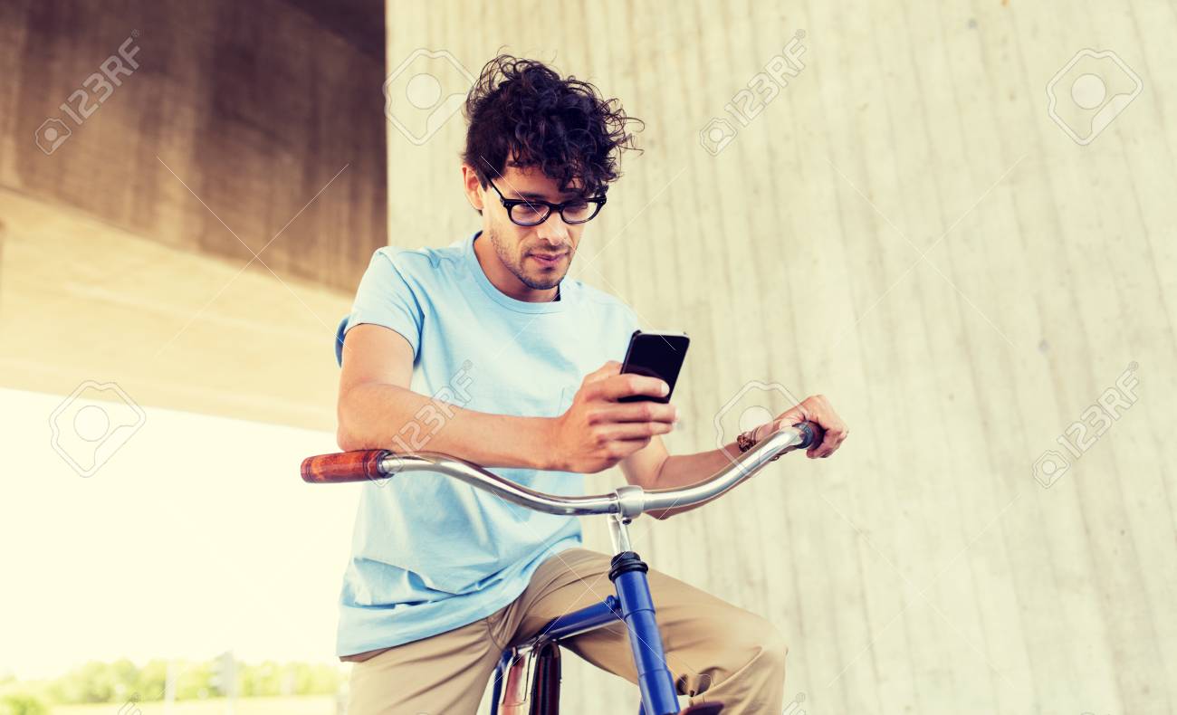 man with smartphone and fixed gear bike on street - 122451828 man with smartphone and fixed gear bike on street - 122451828