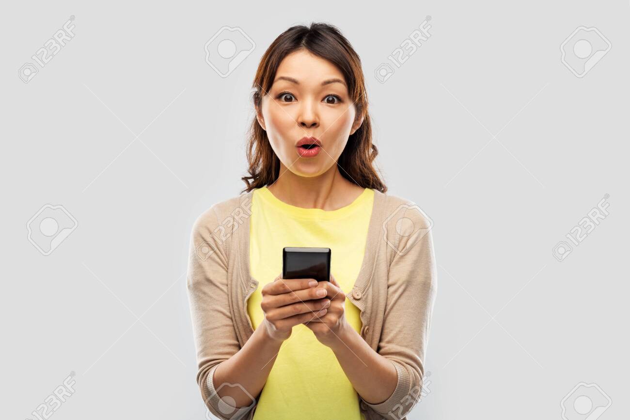 surprised asian woman using smartphone - 124311143 surprised asian woman using smartphone - 124311143